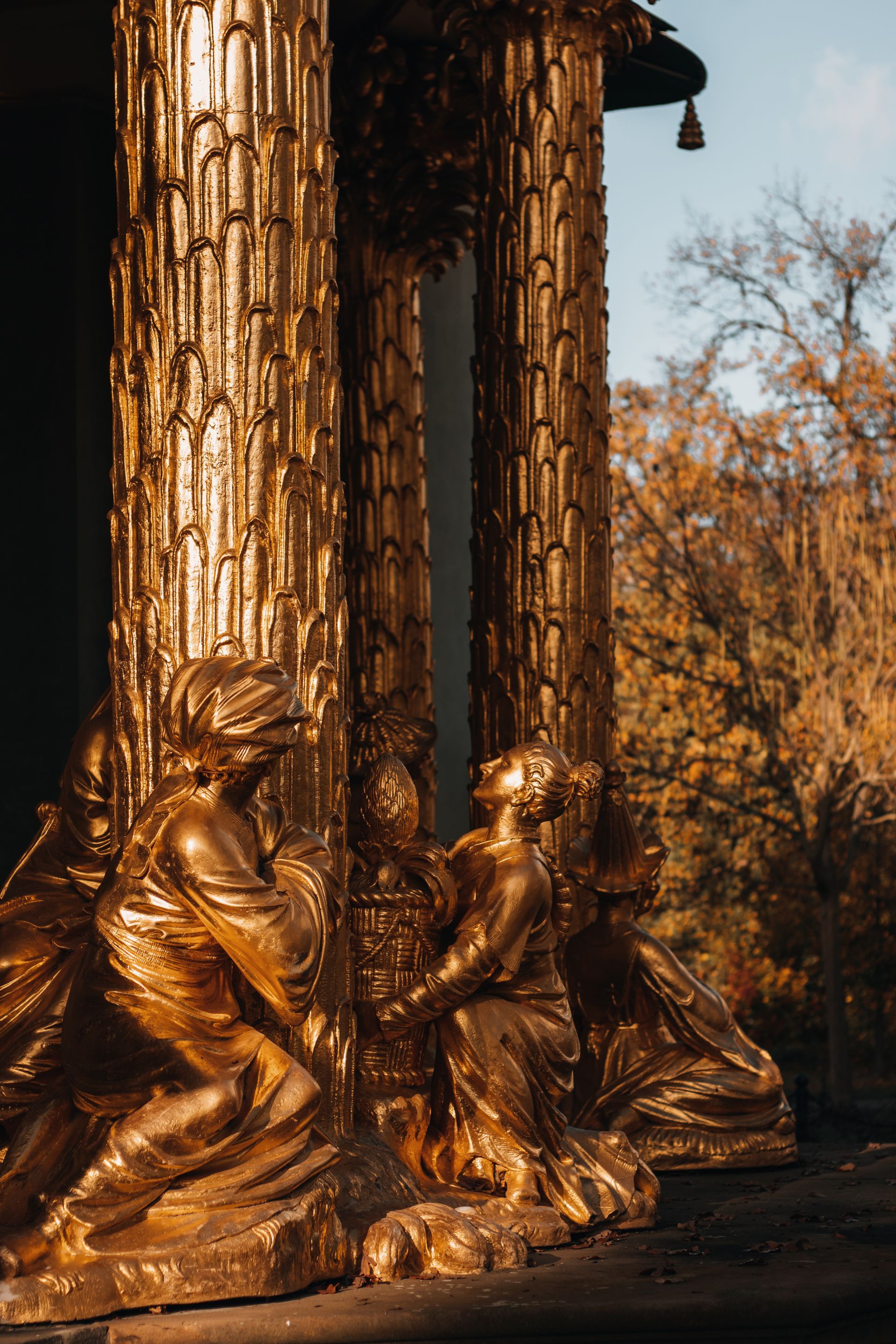 A statue of a man and woman kneeling next to each other in front of a building.
