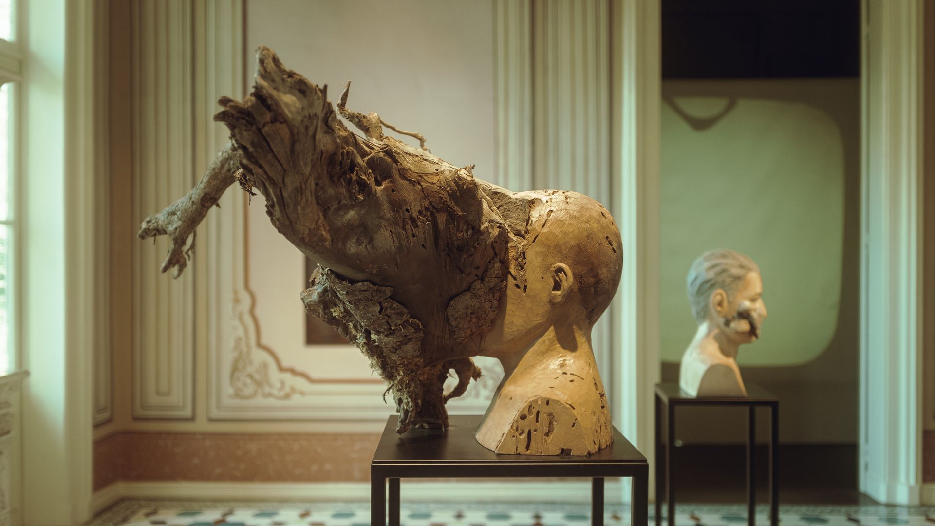 A statue of a man 's head is on display in a museum.