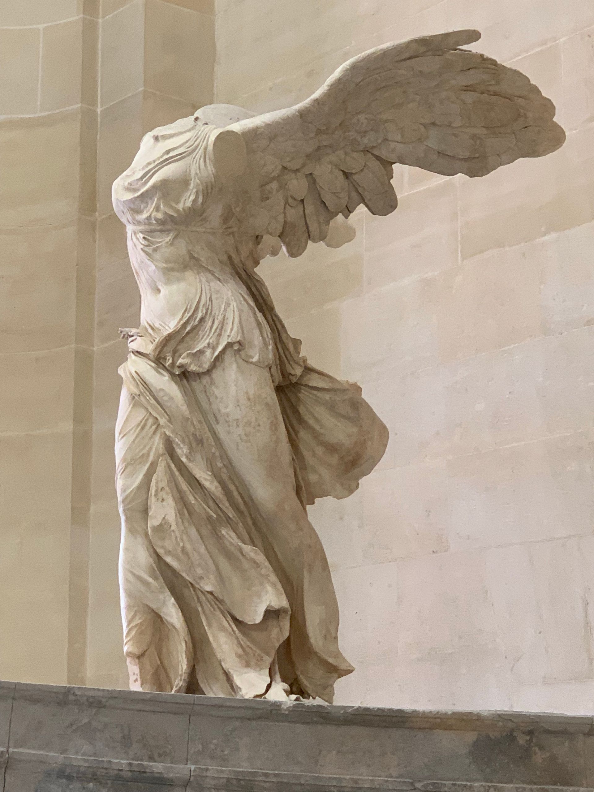 A statue of a woman with wings is standing on a set of stairs