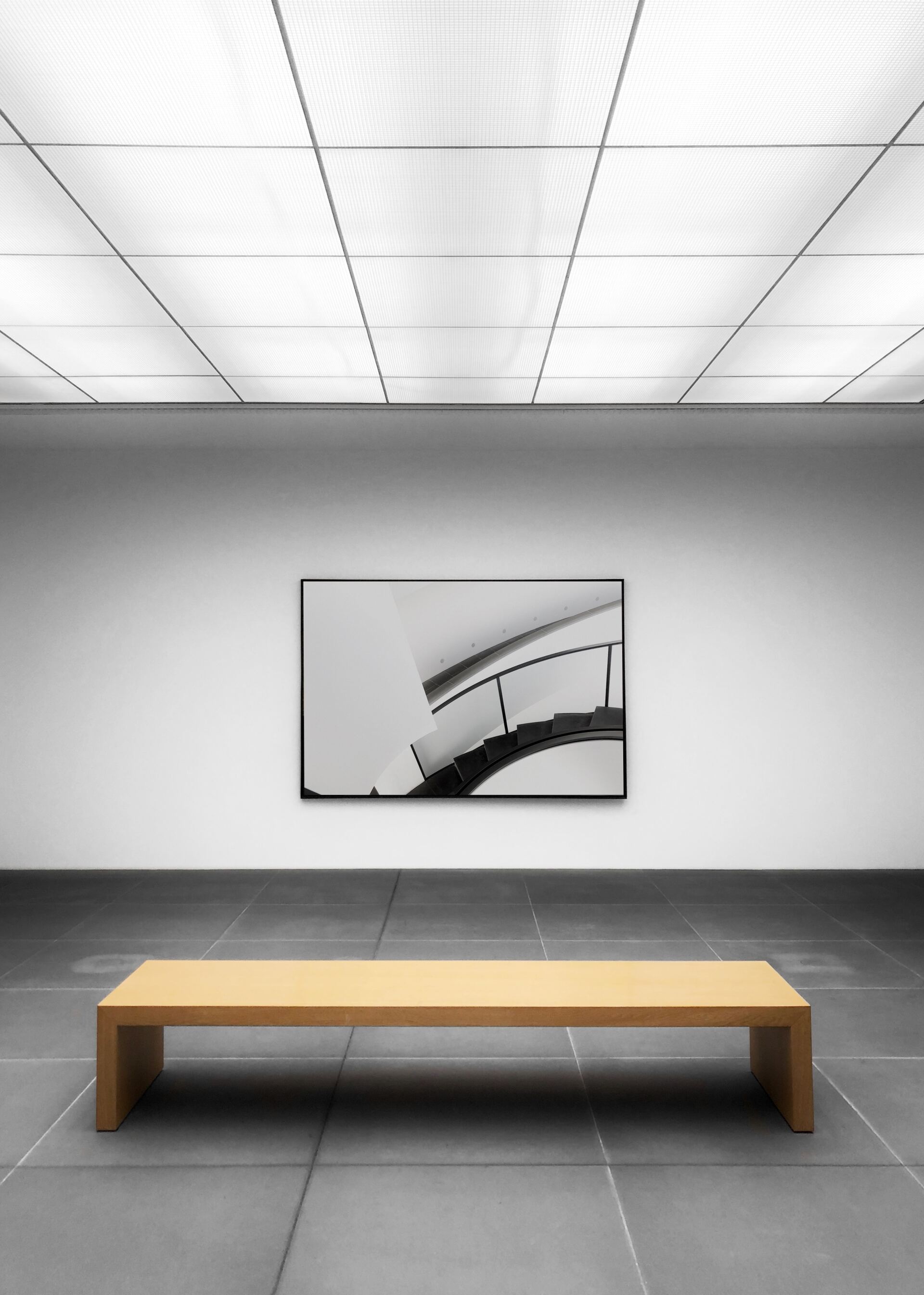 An empty room with a bench and a picture on the wall