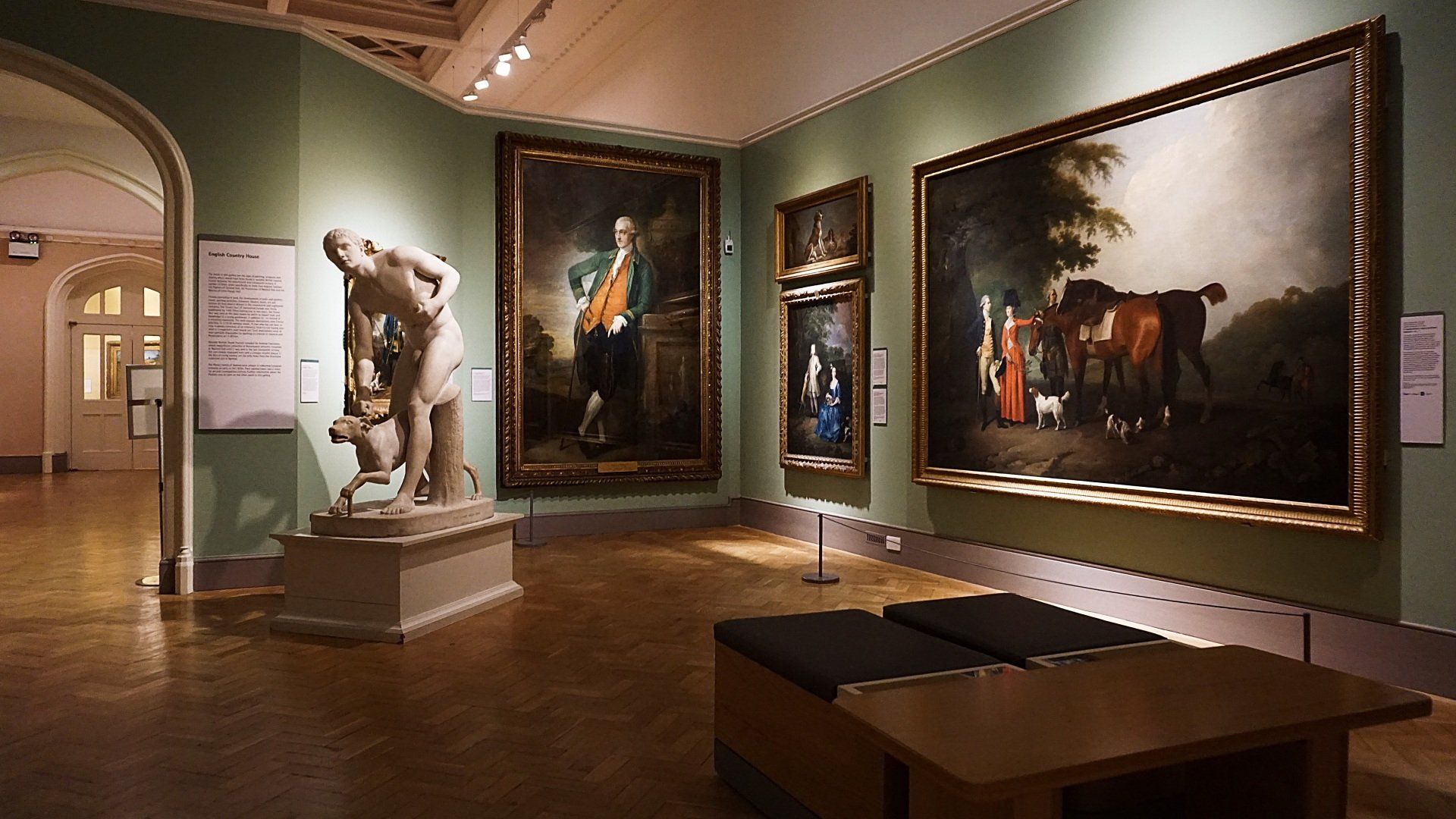 A museum with paintings and a statue on display