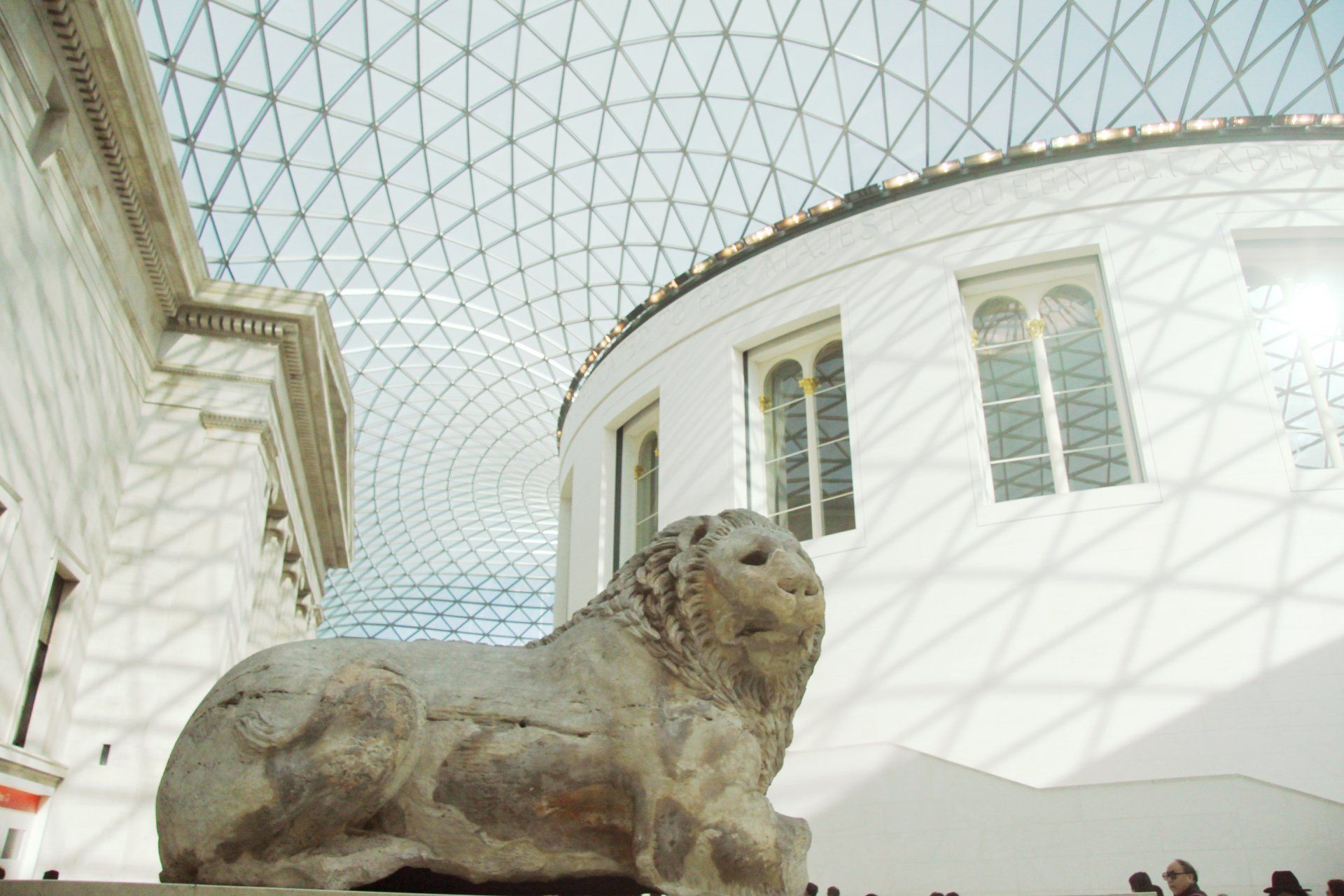 A statue of a lion laying down in a museum